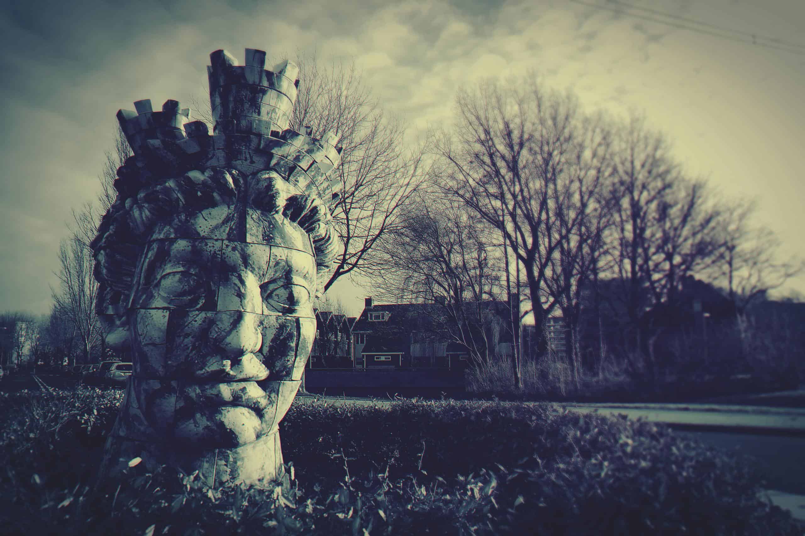 Human Head Statue Near Bare Trees